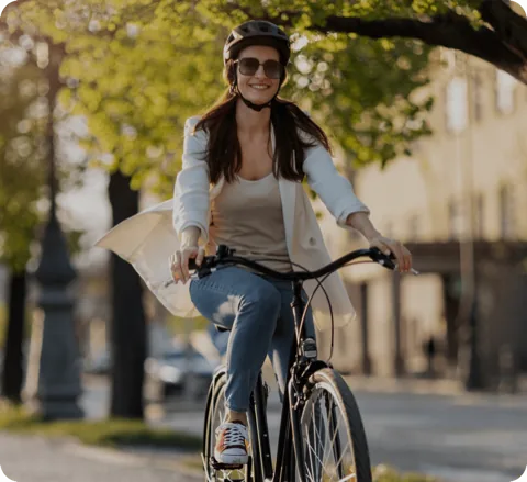 Mujer paseando en bicicleta por una calle arbolada de la ciudad